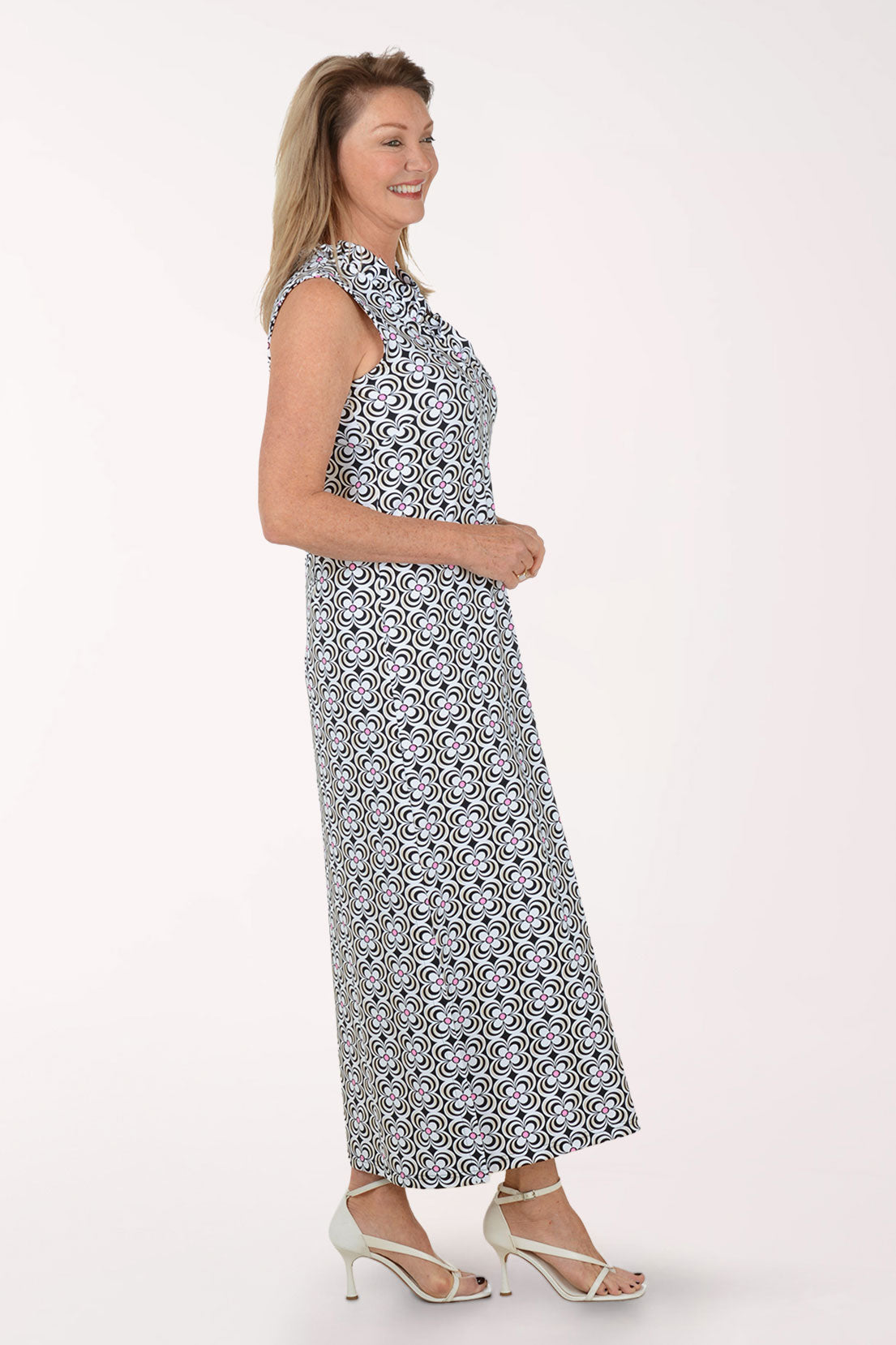 Woman wearing a sleeveless maxi dress with a black and white pattern on a white background.