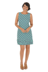Woman wearing a sleeveless teal patterned dress with a triple ruffled hem on a white background.