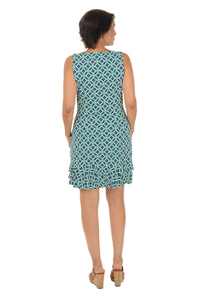 Woman wearing a sleeveless teal patterned dress with a triple ruffled hem on a white background. Back shot.