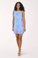 Woman wearing a colorful dress with a white background.