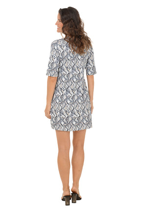 Woman wearing a v-neck 3/4 sleeve snake patterned dress on a white background. Back shot.