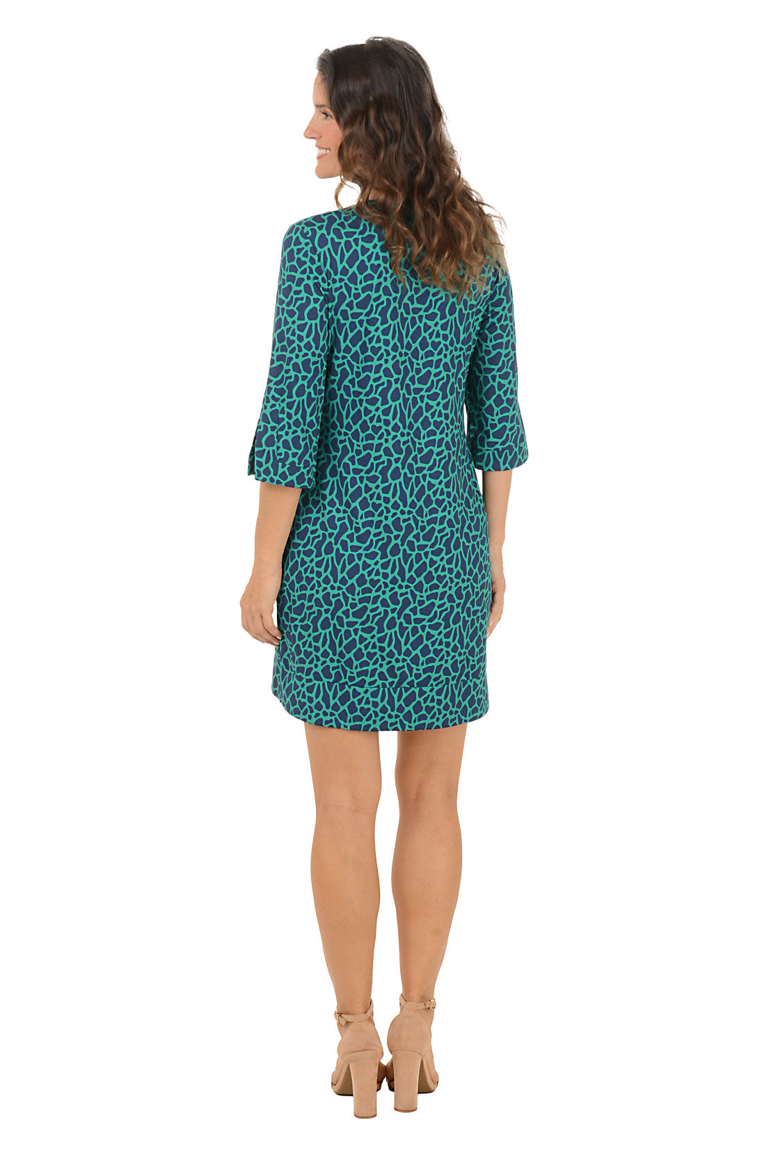 Woman wearing a teal leopard dress on a white background. Back shot.