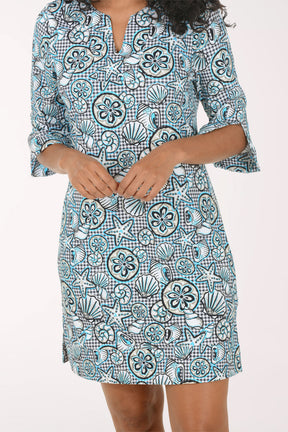 Woman wearing a blue and white patterned dress on a white background.
