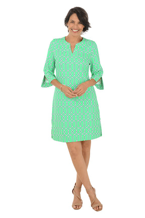 Woman wearing a green patterned dress on a white background.