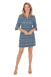 Woman wearing a blue patterned dress on a white background.