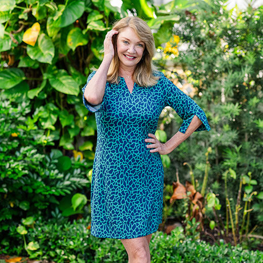 Woman wearing a blue patterned dress standing in a garden