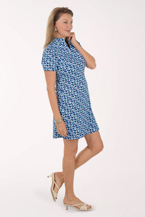 Woman wearing a blue patterned dress on a white background.