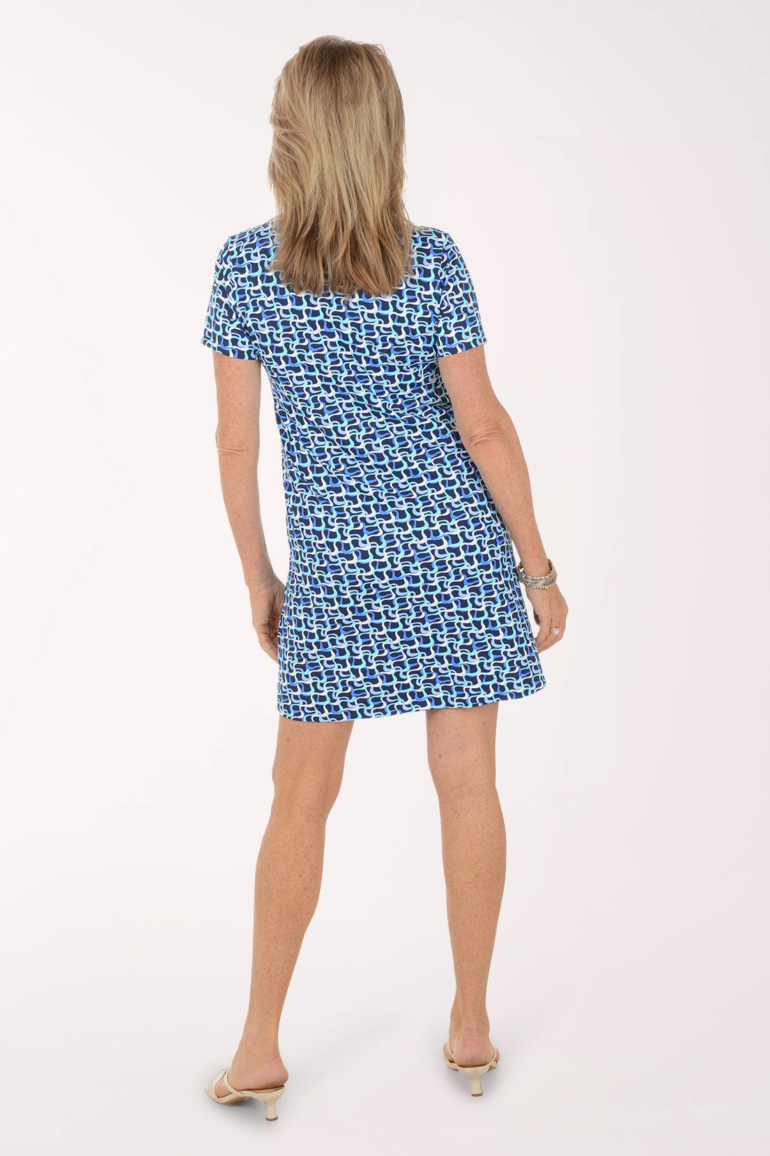 Woman wearing a blue patterned dress on a white background.
