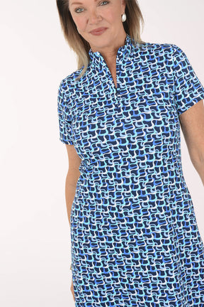 Woman wearing a blue patterned dress on a white background.