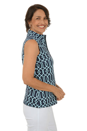 Woman wearing a sleeveless patterned top and white pants on a white background