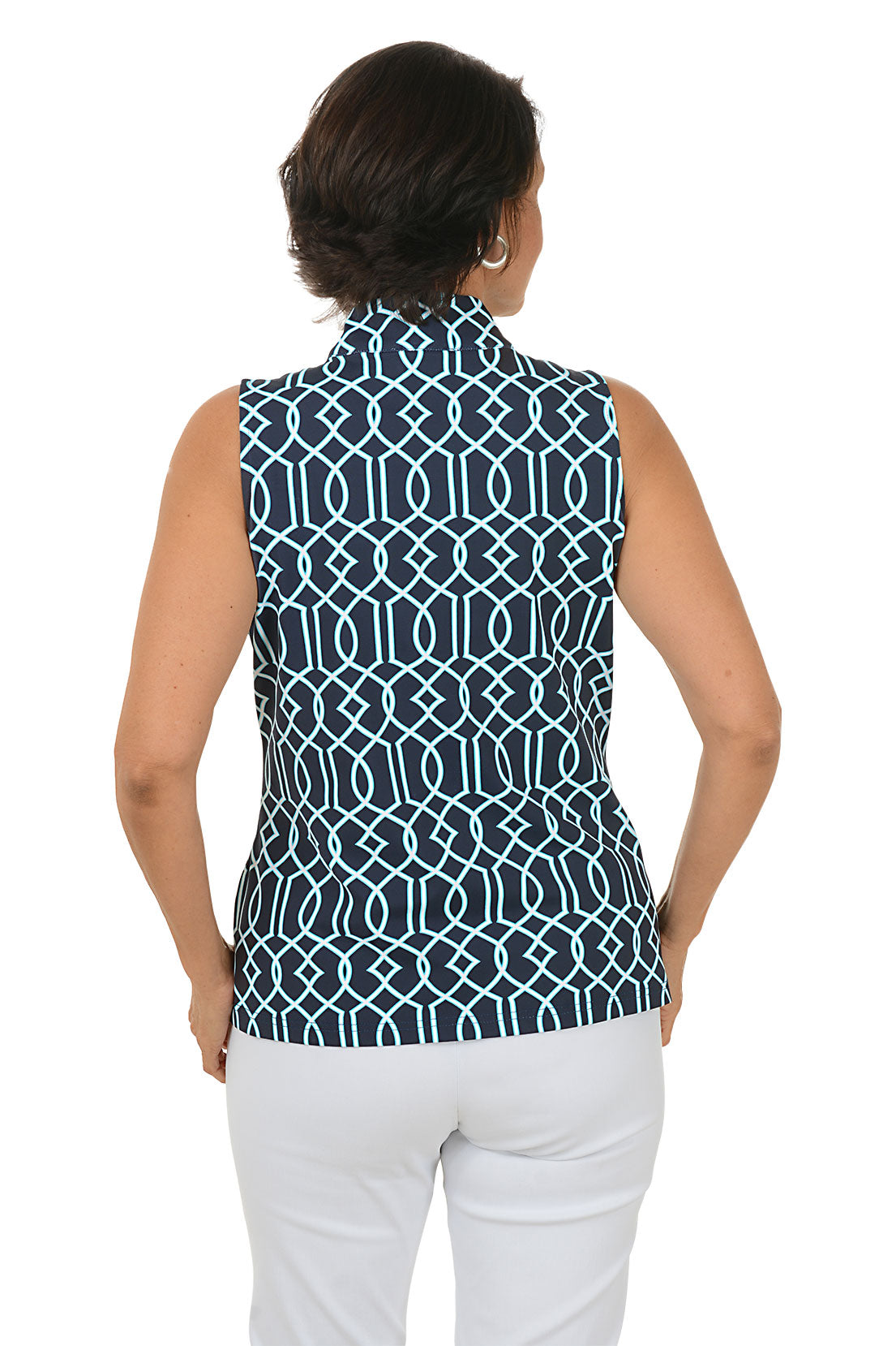 Woman wearing a sleeveless patterned top and white pants on a white background