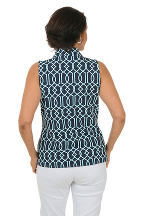 Woman wearing a sleeveless patterned top and white pants on a white background