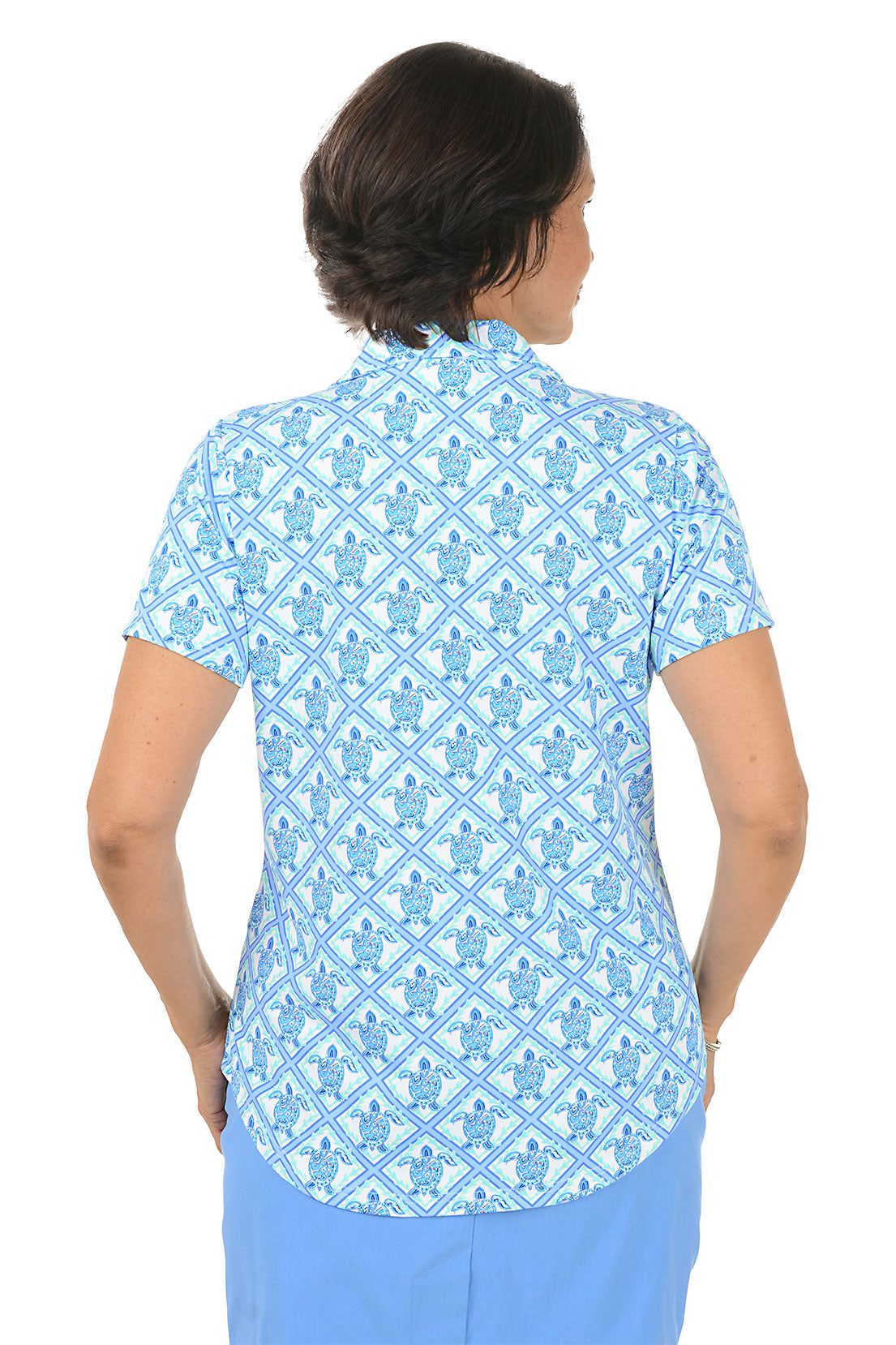 Woman wearing a blue patterned top and skirt on a white background. Back shot.