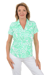 Woman wearing a green floral patterned blouse on a white background.