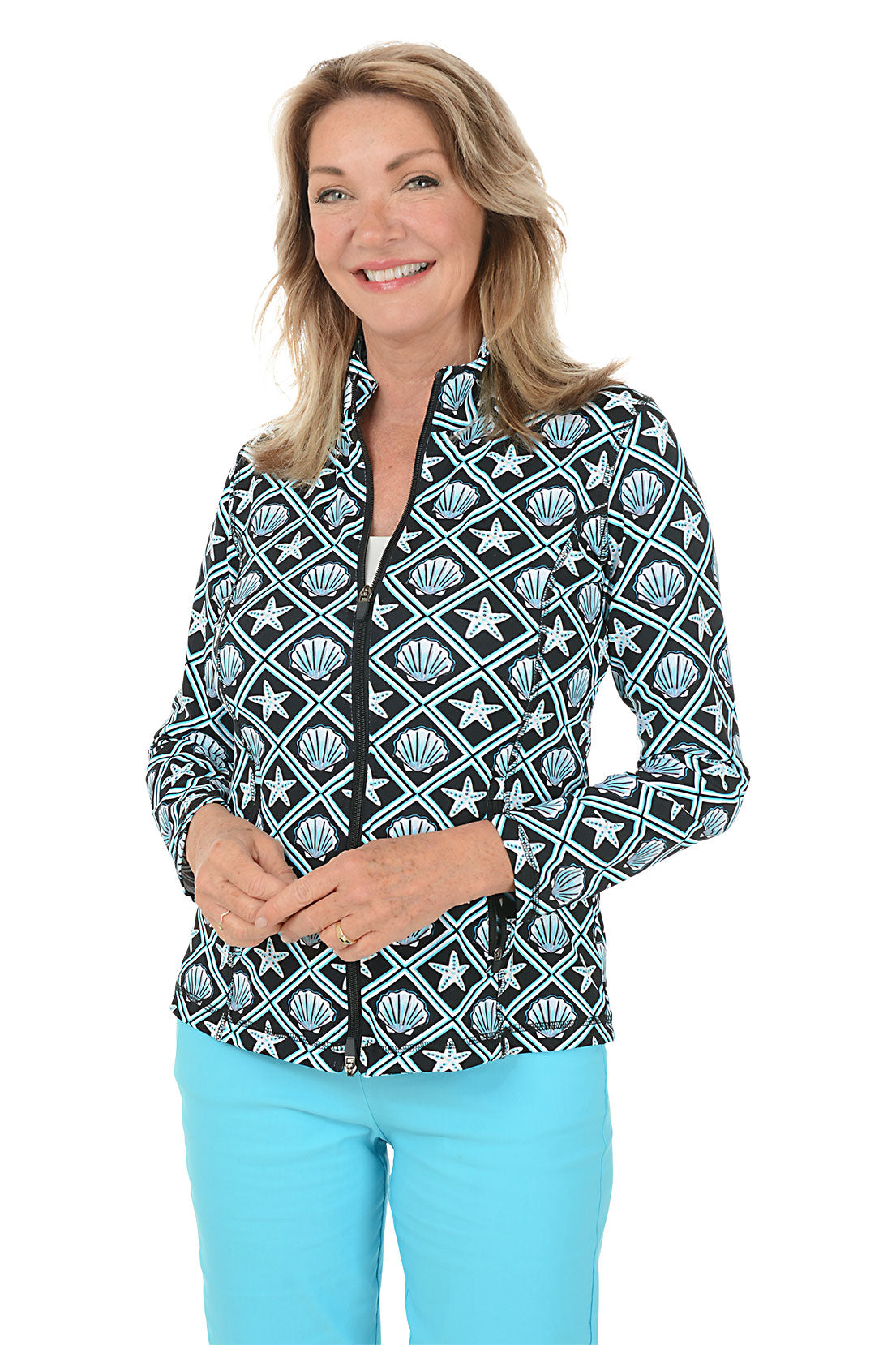 Woman wearing a patterned jacket with starfish and shell design on a white background.