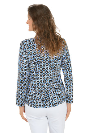 Woman wearing a blue multi patterned jacket with a zipper on a white background. Back shot.