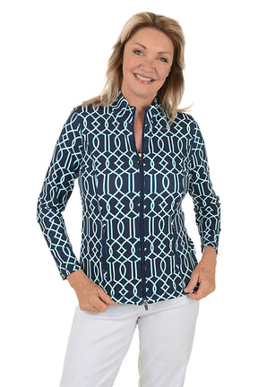 Woman wearing a navy patterned blouse and white pants on a white background