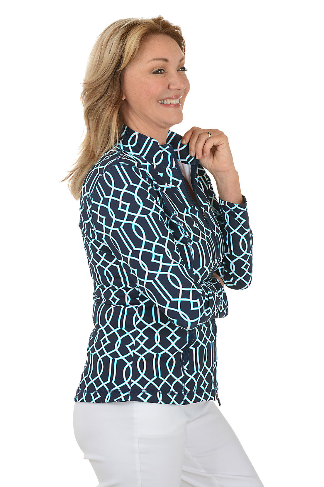 Woman wearing a navy patterned blouse and white pants on a white background