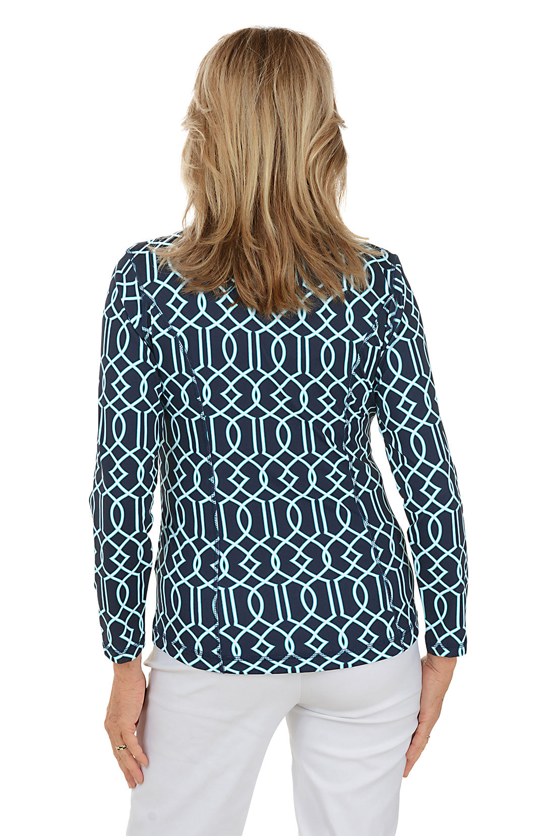 Woman wearing a navy patterned blouse and white pants on a white background