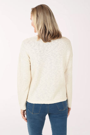 Woman wearing a cream sweater with an American flag design on a white background