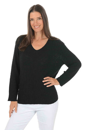 Woman wearing a black sweater and white pants on a white background