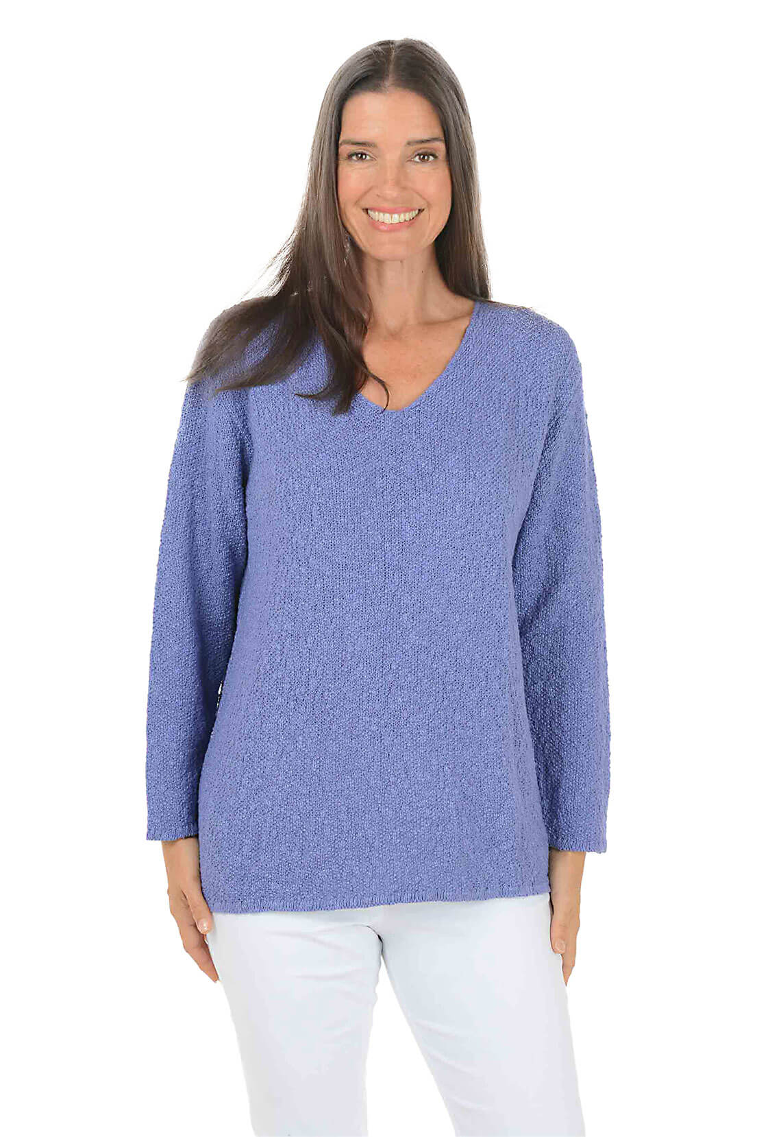 Woman wearing a blue sweater and white pants on a white background
