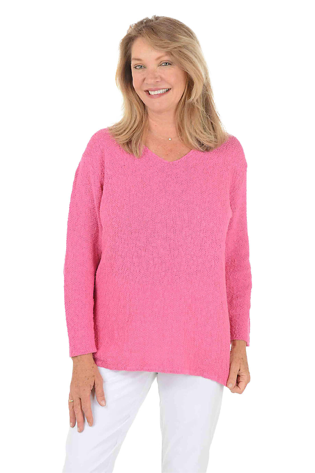 Woman wearing a pink sweater and white pants on a white background