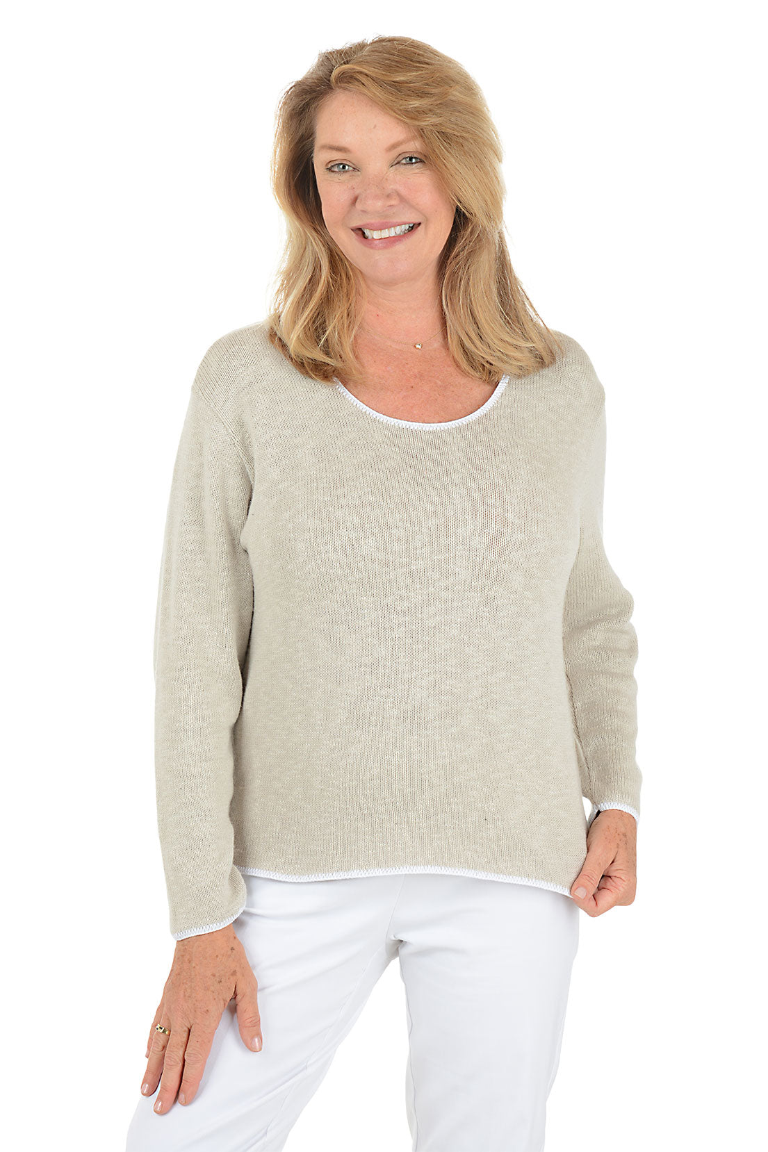 A woman wearing a scoop neck beige sweater with contrast white piping.