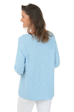 Woman wearing a light blue sweater on a white background