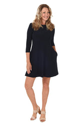 A model wearing a long sleeve navy dress with a scoop neckline, dual side pockets, and a straight hemline.