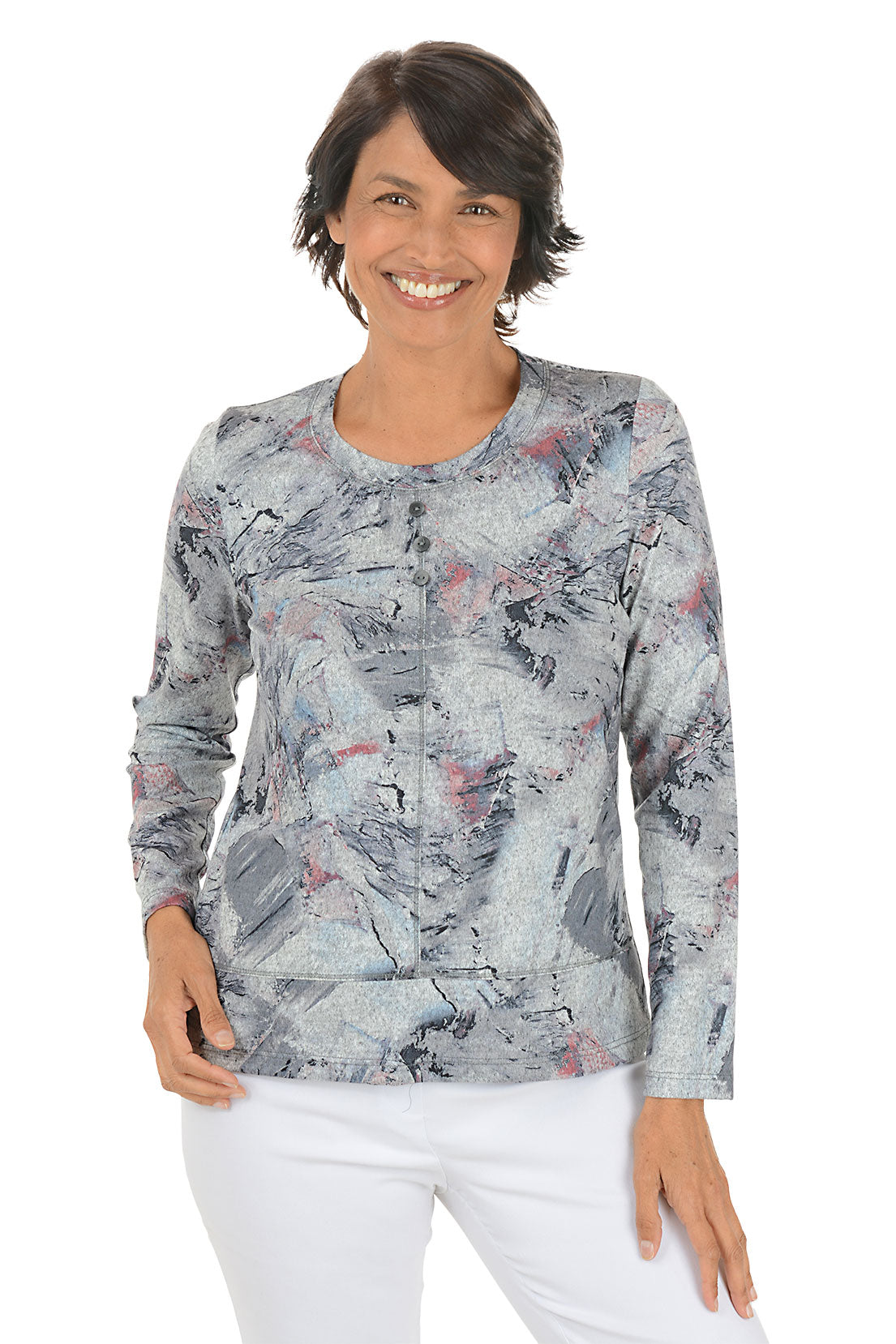 Woman wearing a long-sleeve, patterned top with a white background.