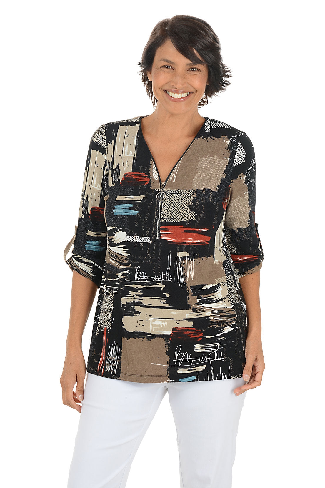Woman wearing a colorful patterned blouse with white pants on a white background.