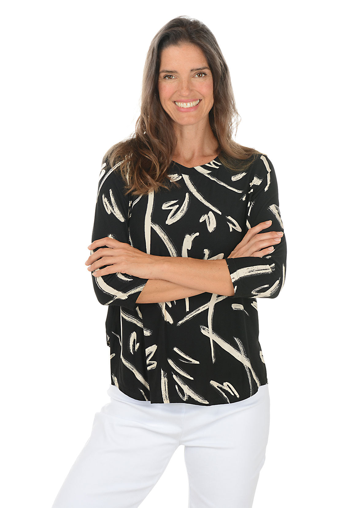 Woman wearing a black and white patterned top with arms crossed on a white background.