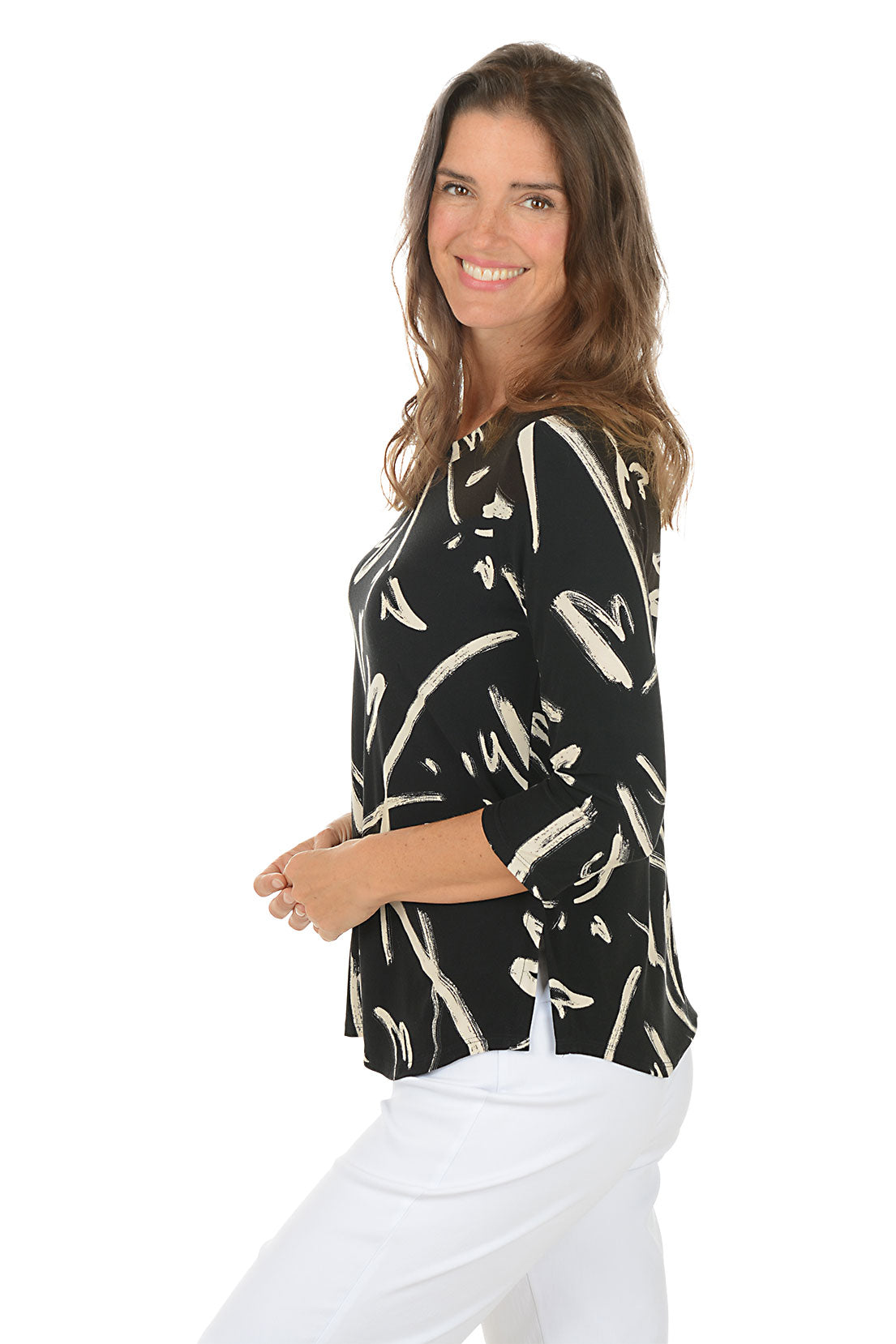 A woman wearing a black and white 3/4 sleeve top with an abstract pattern. Side shot.