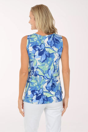 Woman wearing a blue floral sleeveless top against a white background