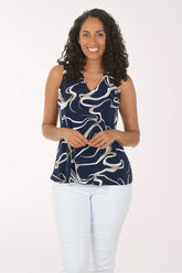 Woman wearing a sleeveless top with a blue and white abstract pattern on a white background