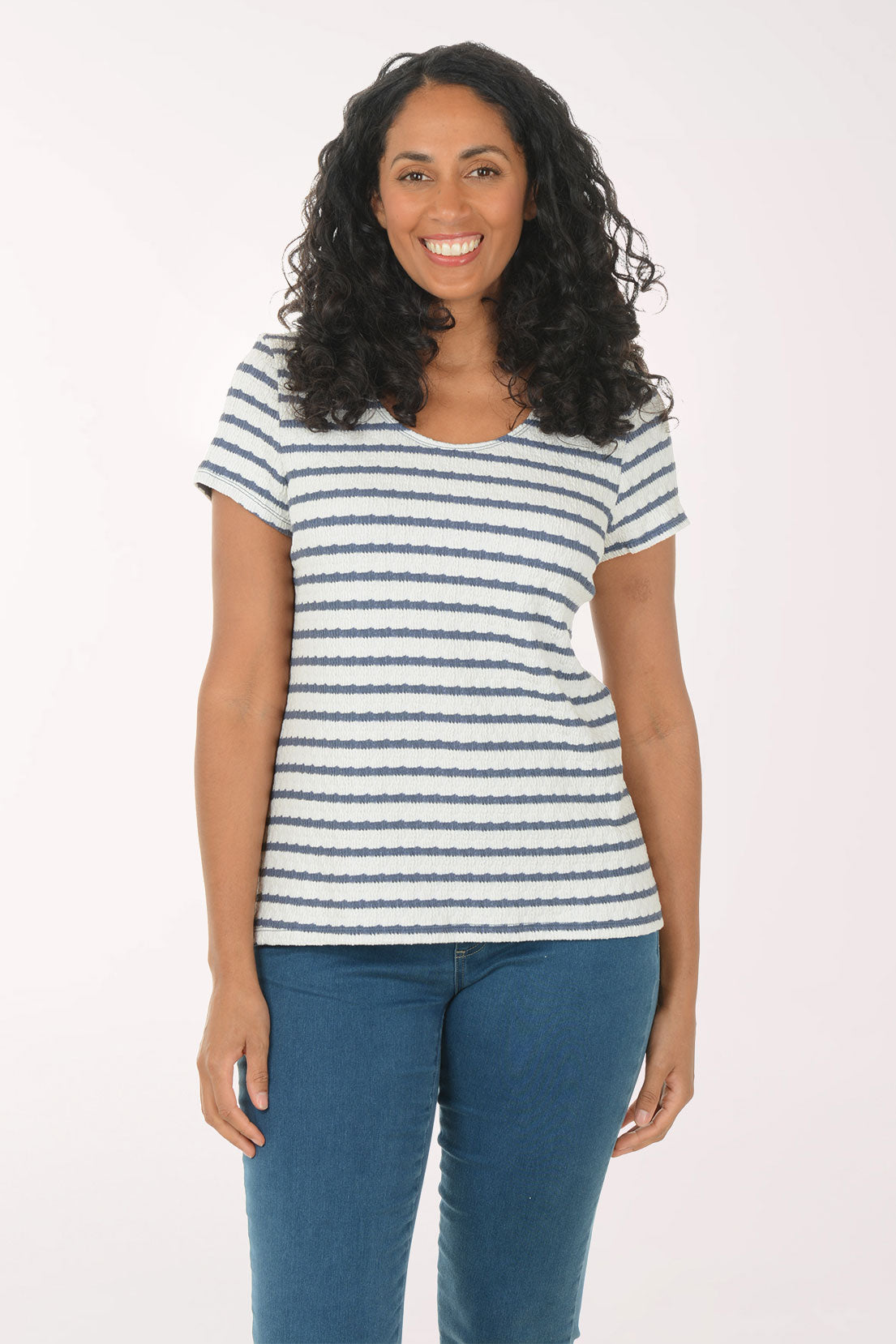 Woman wearing a striped shirt and blue jeans on a white background