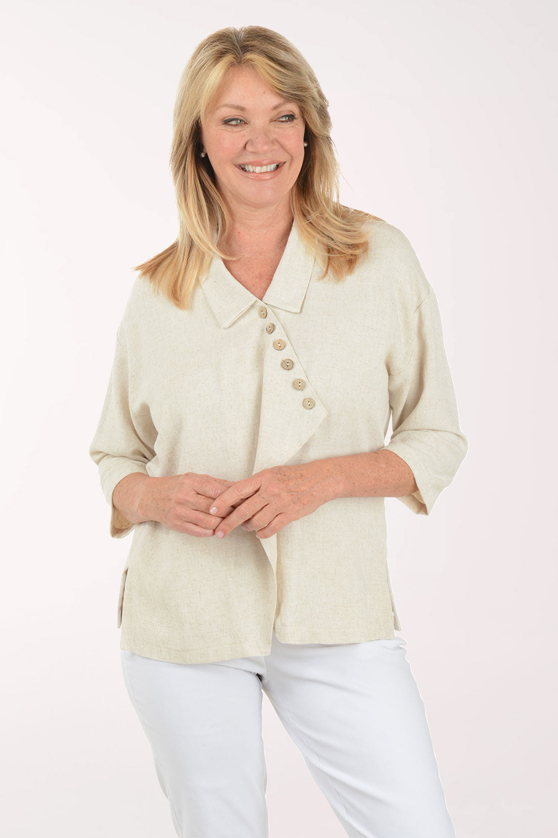 Woman wearing a light-colored blouse with buttons on a white background