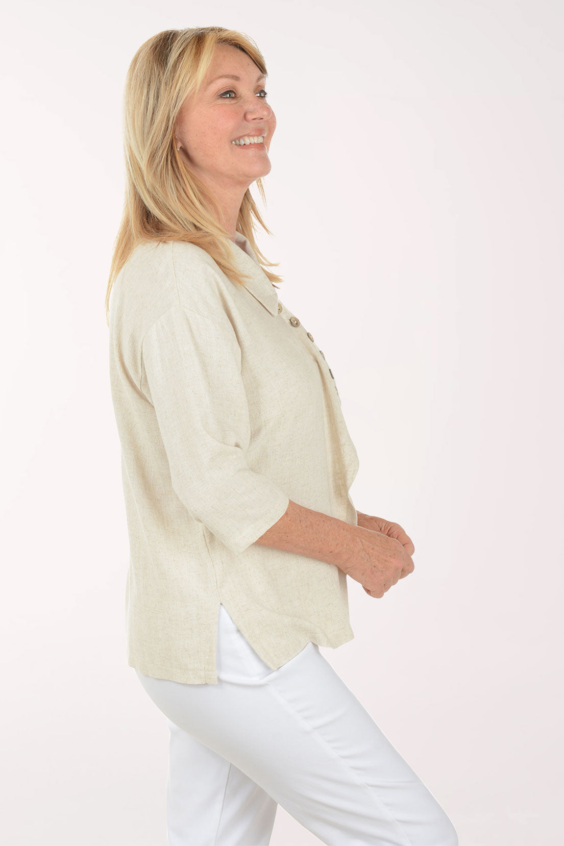 Woman wearing a light-colored blouse with buttons on a white background