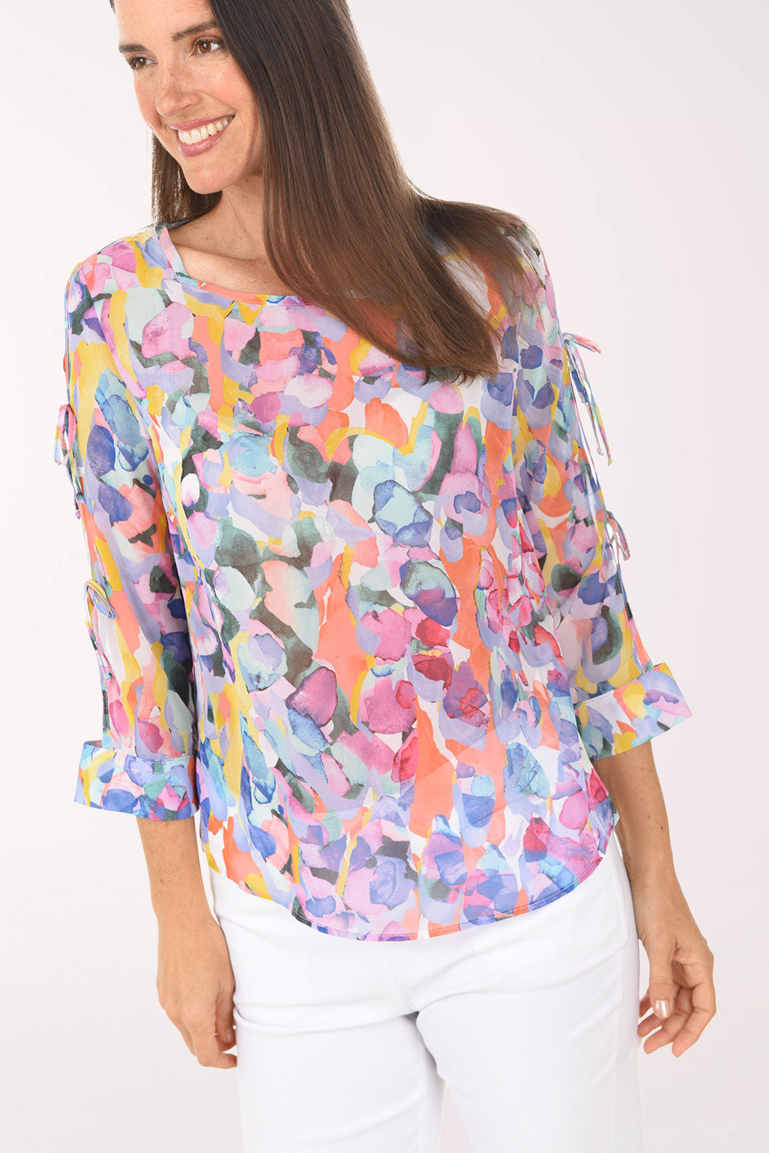 Woman wearing a colorful floral blouse against a white background