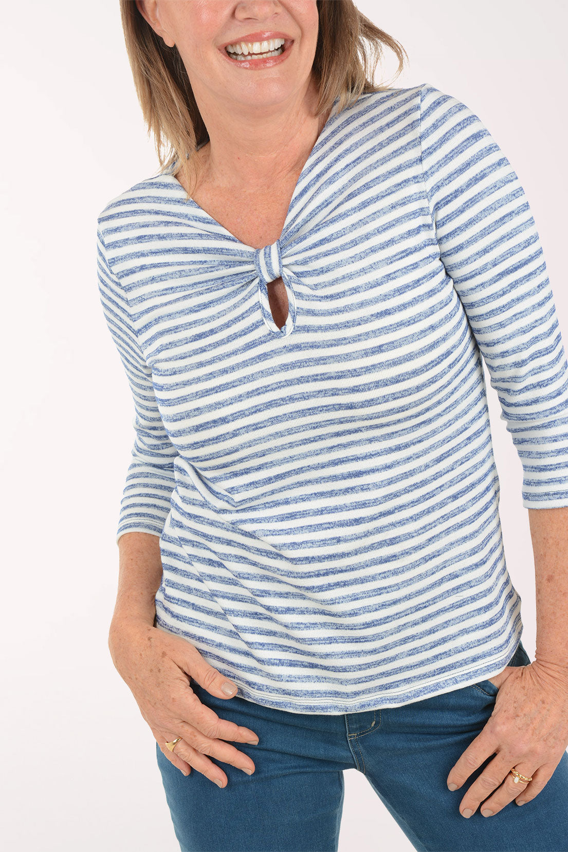 Woman wearing a blue and white striped top with a knot detail on a white background