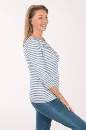 Woman wearing a blue and white striped shirt with a white background