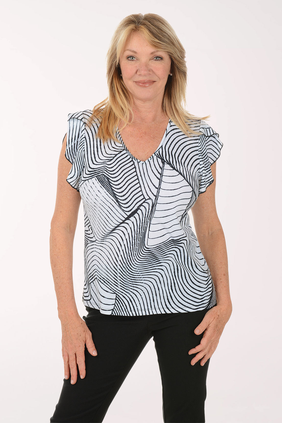 Woman wearing a black and white patterned top on a white background