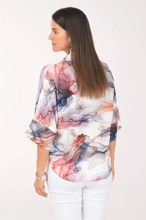 Woman wearing a colorful abstract patterned blouse on a white background