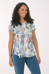 Woman wearing a floral print top and blue jeans on a white background