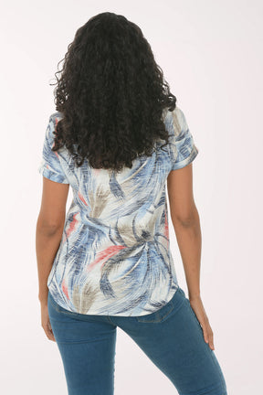 Woman wearing a floral print top and blue jeans on a white background
