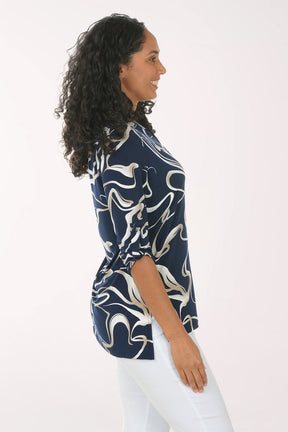 Woman wearing a navy blue and white patterned blouse against a white background