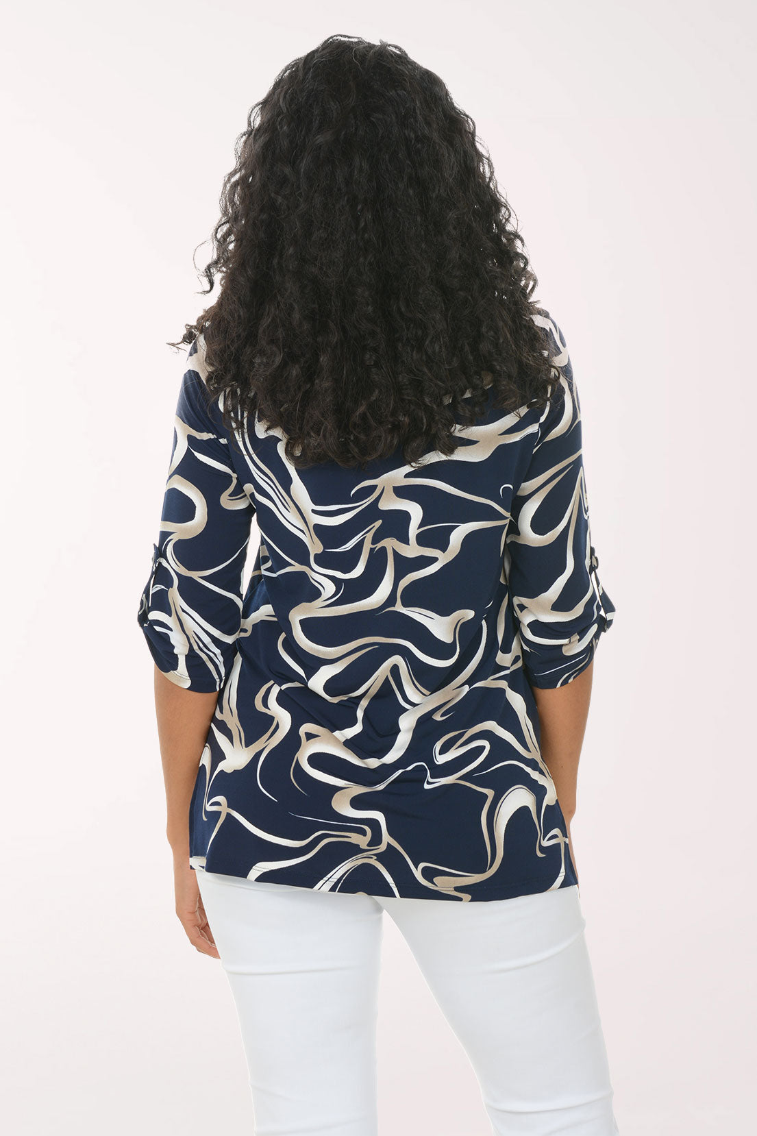 Woman wearing a navy blue and white patterned blouse against a white background