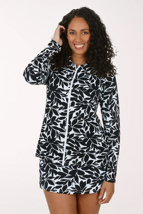 Woman wearing a black and white floral long-sleeve rash guard and matching bottoms on a white background