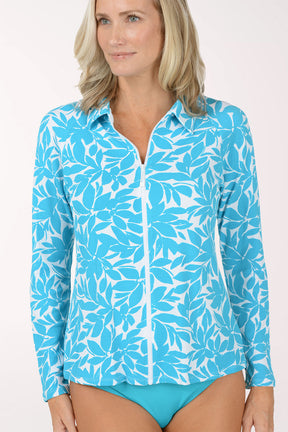 Woman wearing a blue floral long-sleeve rash guard and matching bottoms on a white background